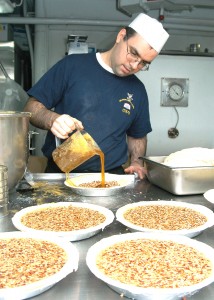 MS2  Joshua Derode from Minneapolis, Min., prepares pecan pies for the big Thanksgiving dinner aboard the carrier USS George Washington. U.S. Navy photo by PHAN Rex Nelson.